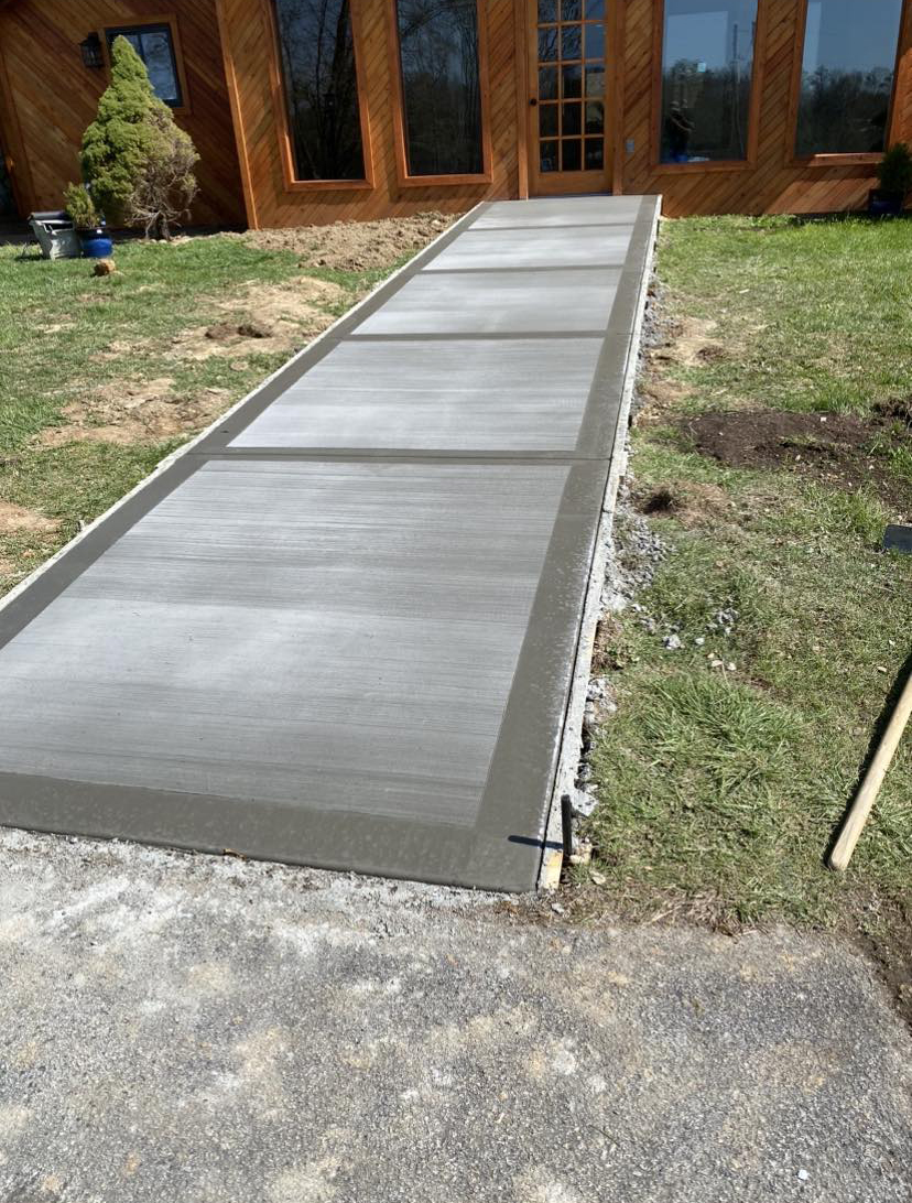 Concrete walkway leading to a log home entrance