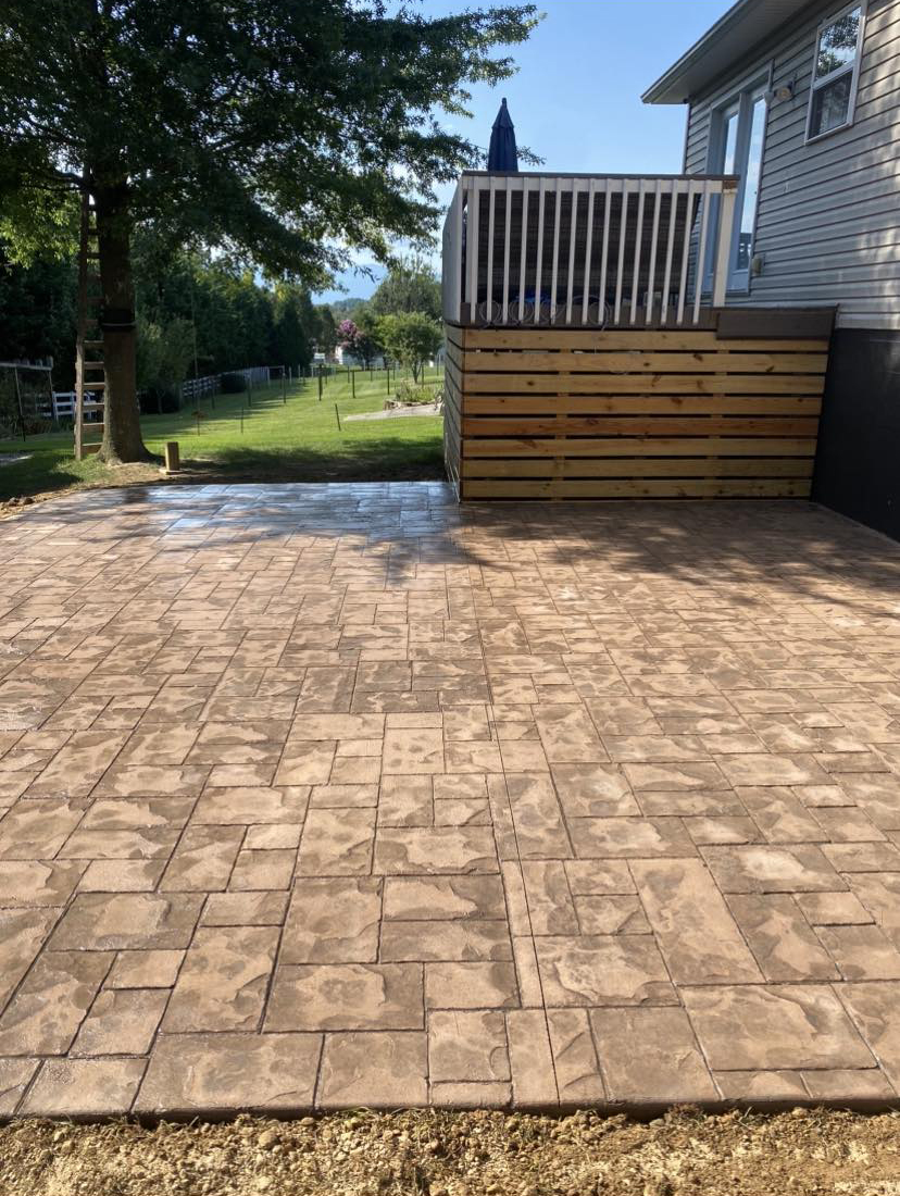 Large stamped concrete patio installation next to a home