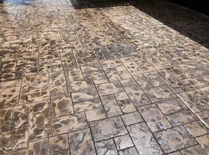 Close-up detail of stamped and stained concrete texture from a Complete Property Management project